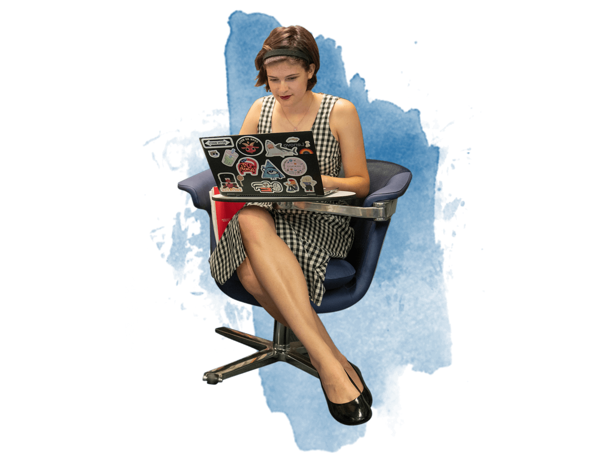 一个女学生坐在椅子上用她的笔记本电脑工作