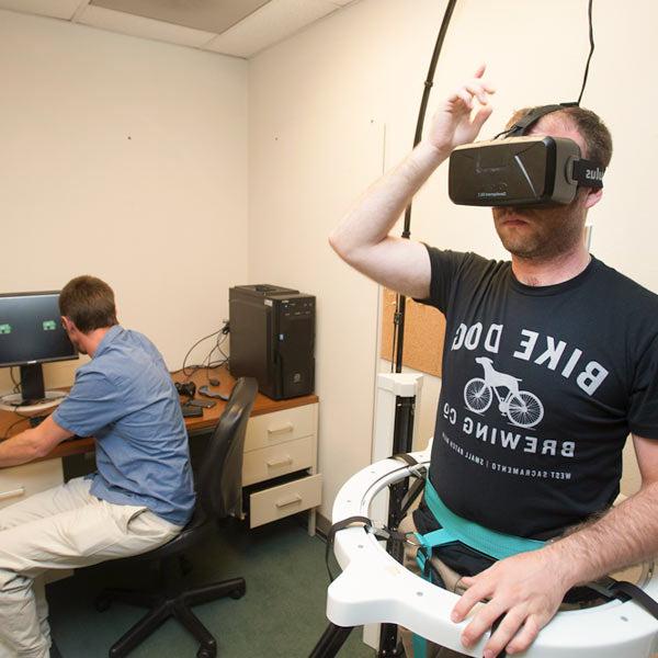 一名戴着虚拟现实头盔的男学生, 探索一个虚拟世界，作为一个心理实验