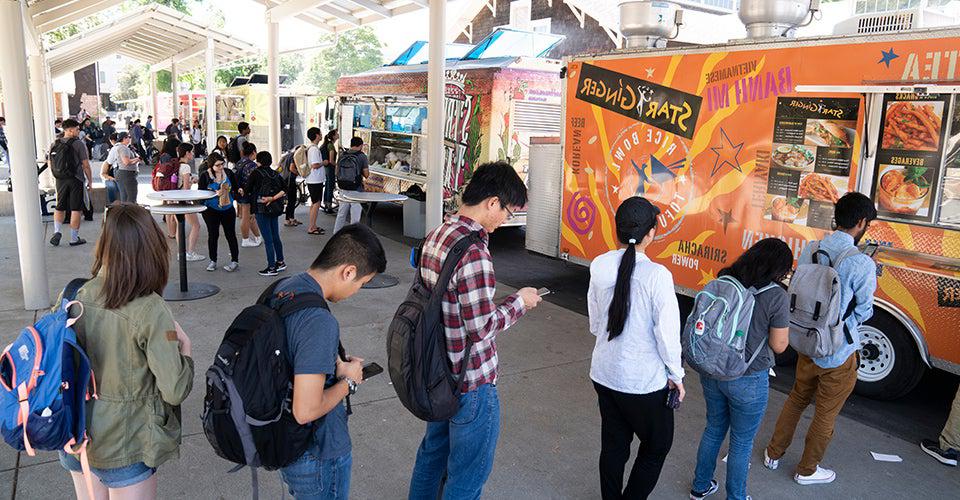 学生们在停在澳门十大电子游戏大全的餐车旁等候食物