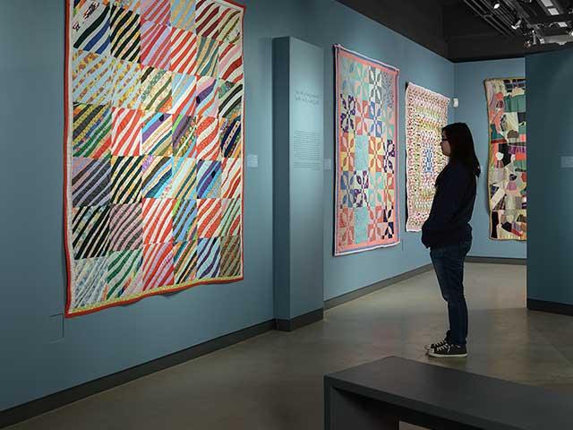 一个学生在设计博物馆里看着墙上的一件大型艺术品