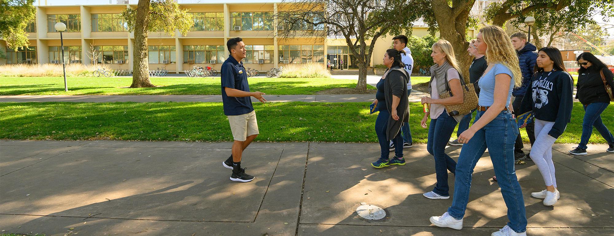 a student tour guide leading a group of people on a campus tour