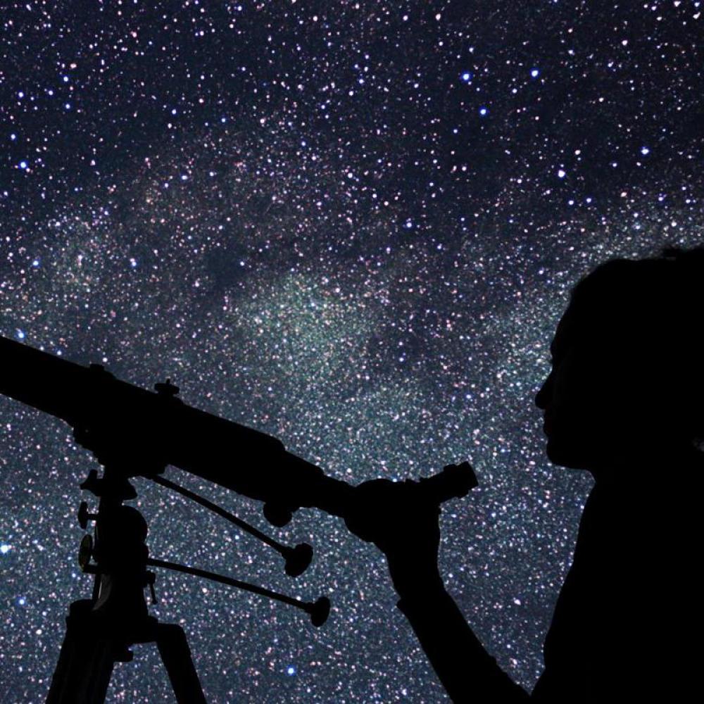 用望远镜观察满天星斗的人
