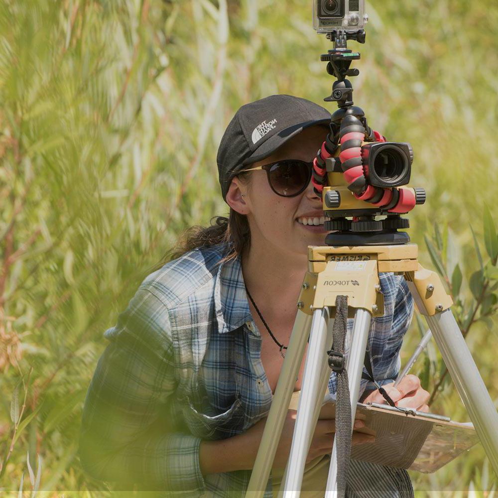 一名学生在荒野地区查看测量工具