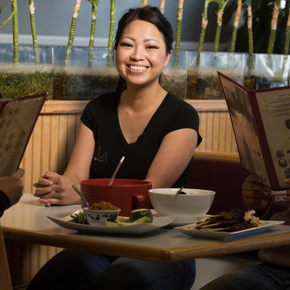 一名女子坐在加州戴维斯当地一家餐馆的摊位上