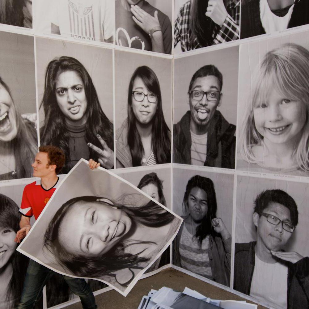 一名学生在澳门十大电子游戏大全社会科学大楼的墙上贴了几张肖像画
