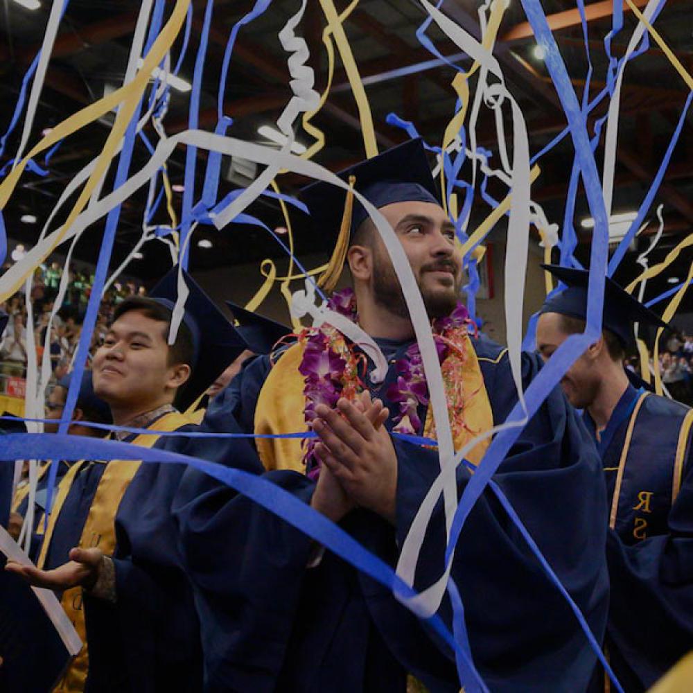一名学生在毕业典礼上欣赏从天花板上落下的彩带